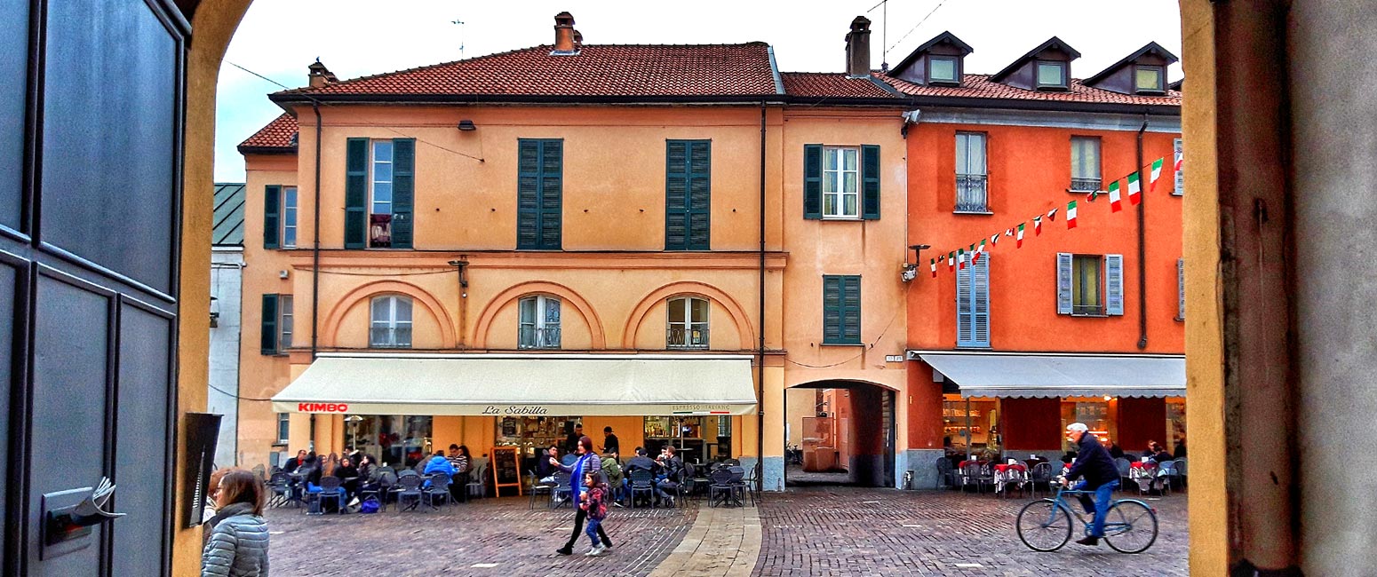 immagine di una strada di rho in cui ci sono bar e persone che passeggiano